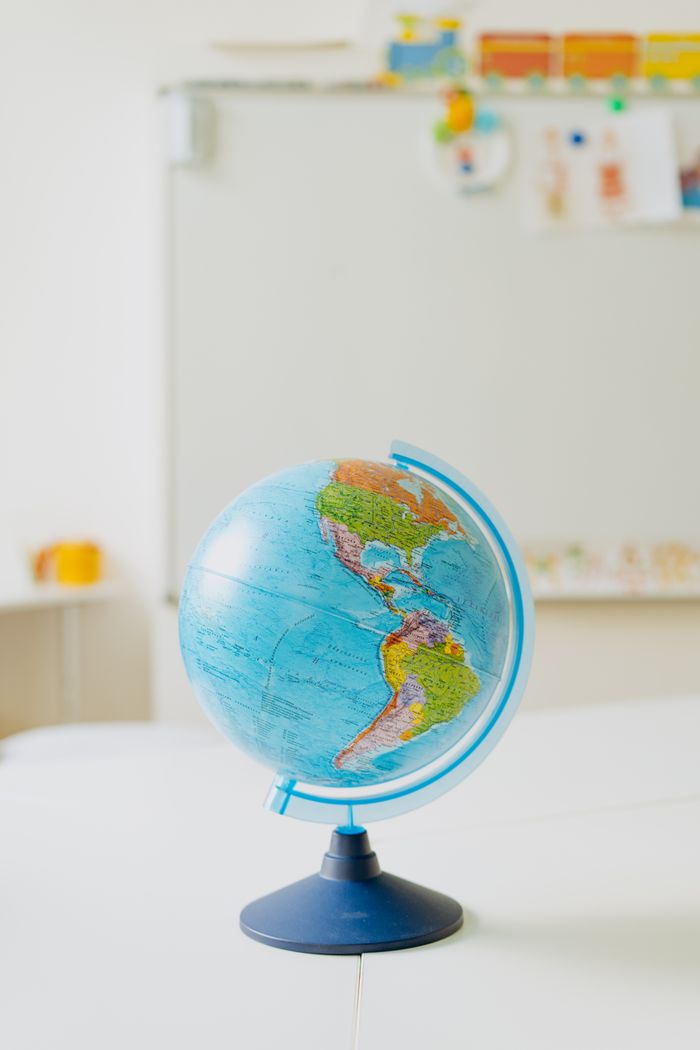 Colorful globe model placed on a classroom table, ideal for educational themes.